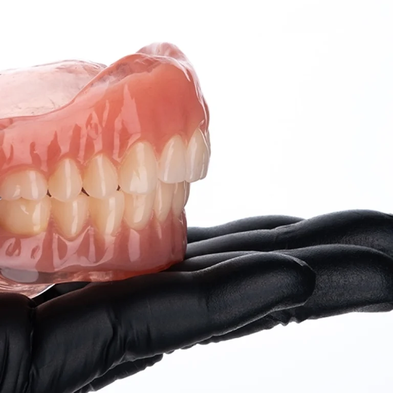upper_lower_complete_dentures_hand_selective_focus-_convert.io_